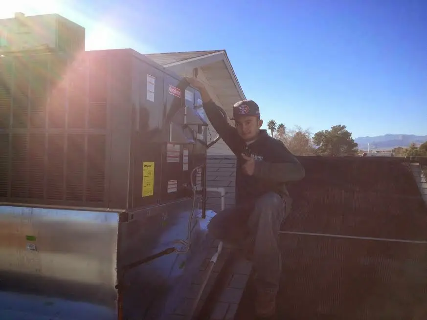 HVAC technician performing Heat Pump Repair on a rooftop unit in Philadelphia